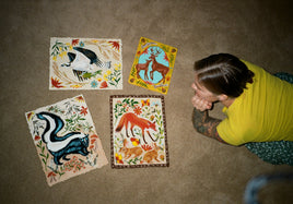 Jennifer Tanay on the floor with some of her prints