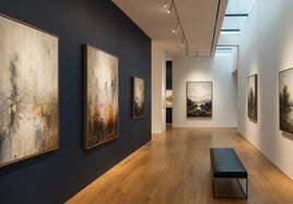 Contemporary art gallery interior with framed artwork and a dark accent wall