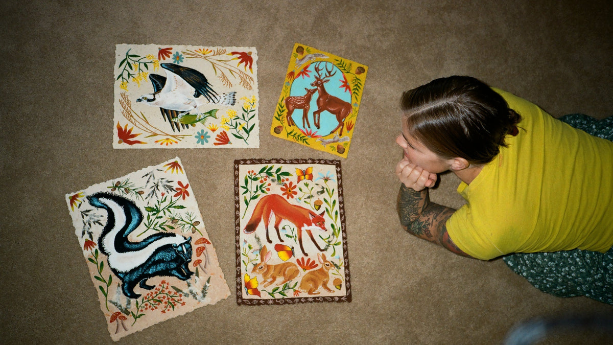 Jennifer Tanay on the floor with some of her prints