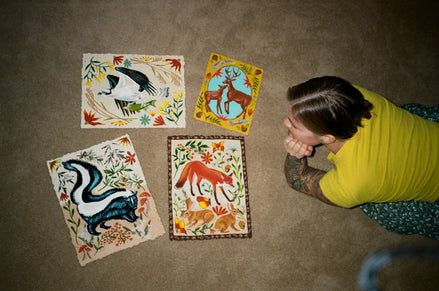 Jennifer Tanay on the floor with some of her prints