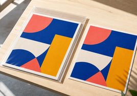 Retail ready print with backing board and clear bag beside the same loose paper print