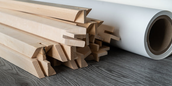 photo of a pile of wooden stretcher bar and a roll of canvas.