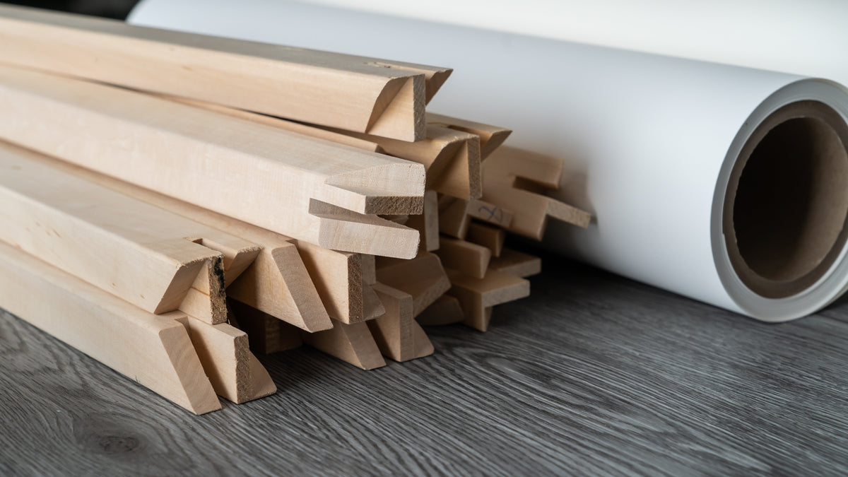 photo of a pile of wooden stretcher bar and a roll of canvas.