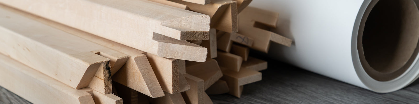 photo of a pile of wooden stretcher bar and a roll of canvas.