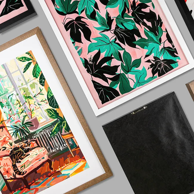 Overhead arrangement of black, white, and walnut-stain framed art prints