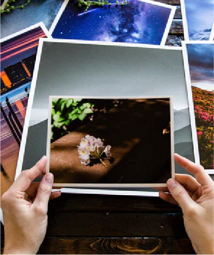 Hands holding a proof print over a studio desk